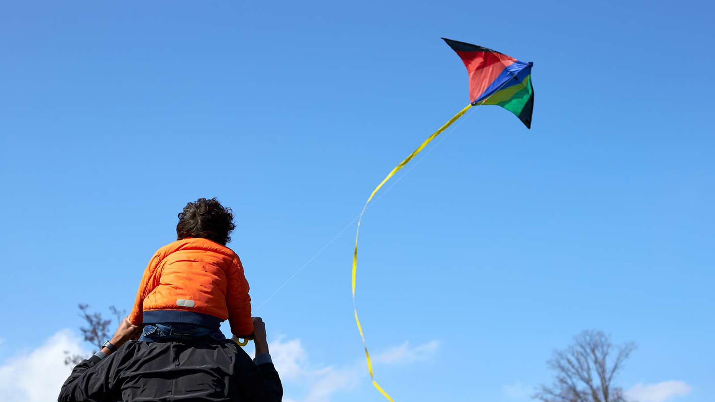 far och son leker med drake utomhus