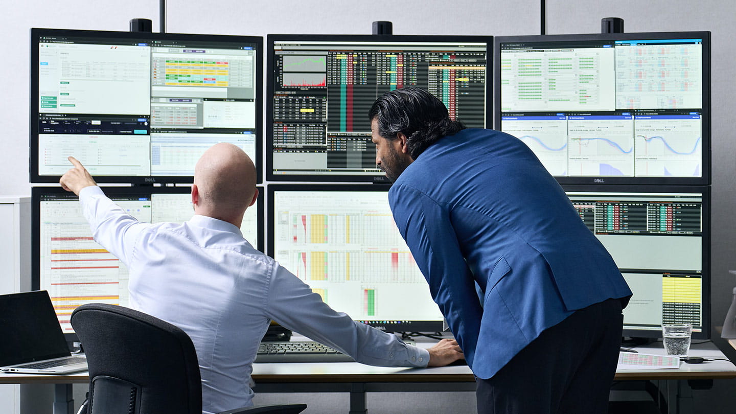 Energy analysts reviewing power market data and trading screens