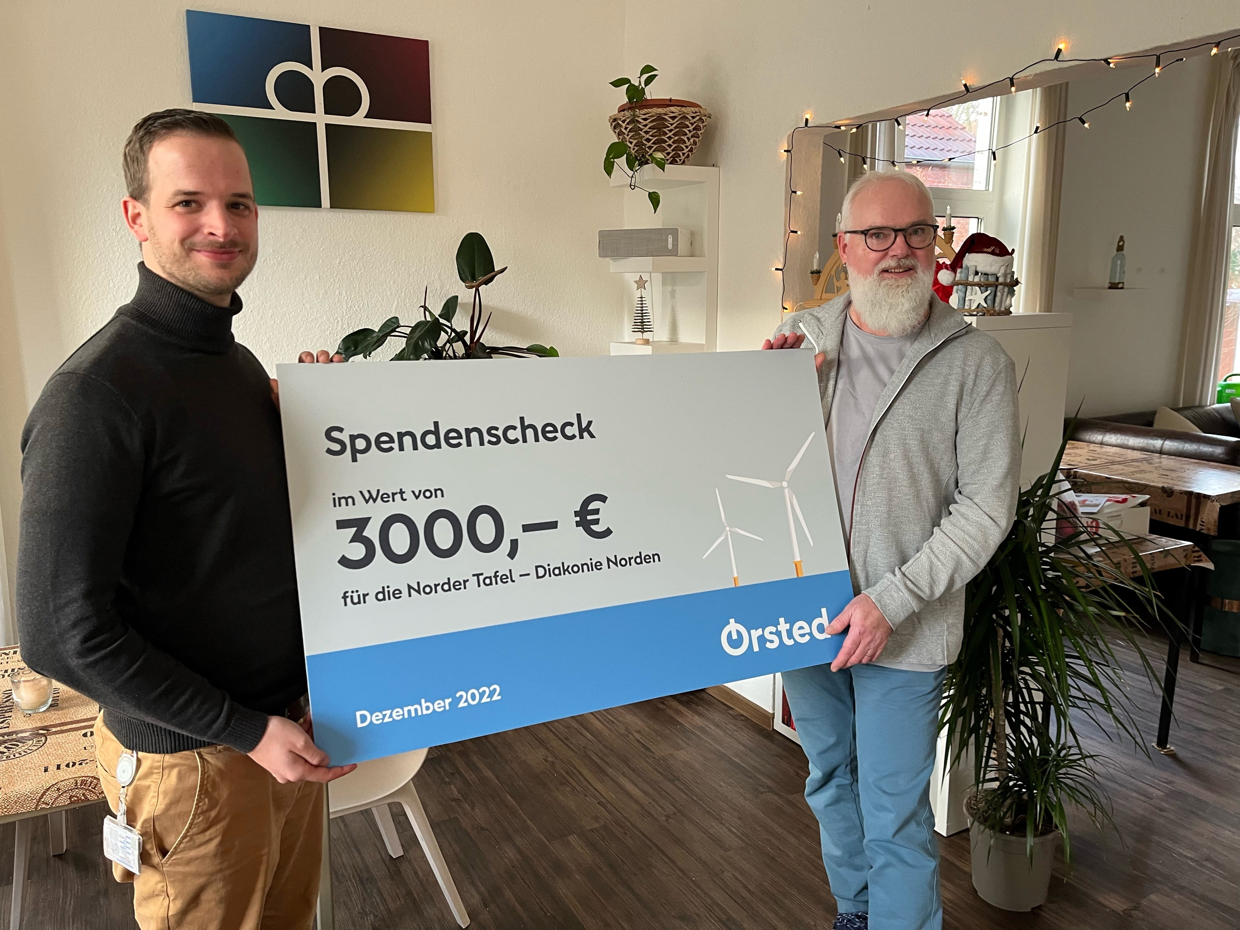 Thijs Schless, Leiter der Betriebsführung bei Ørsted, übergibt den Spendenscheck an die Tafel in Norden