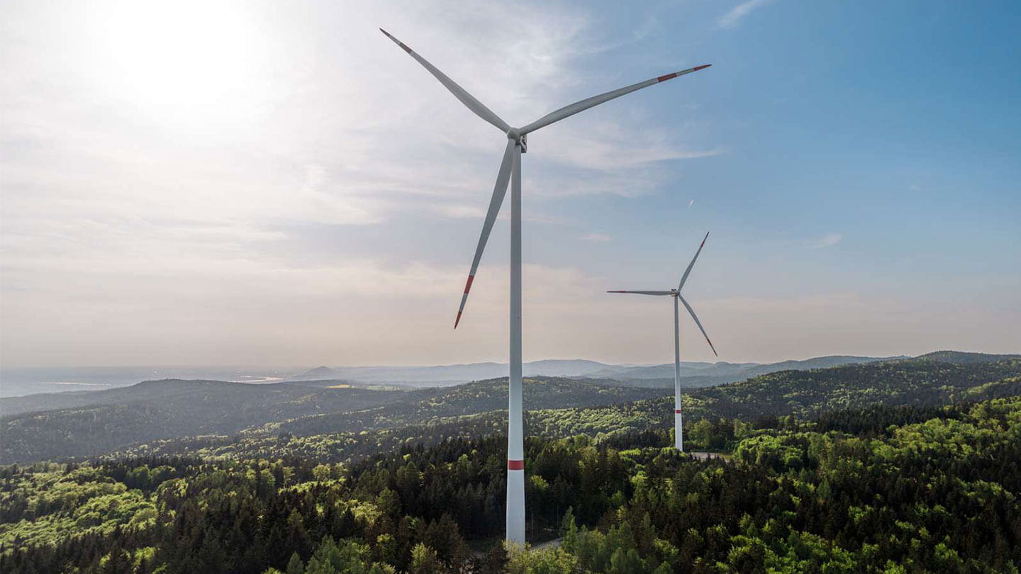 Wind turbines over green hills, reflecting Orsted's renewable energy projects and career opportunities.