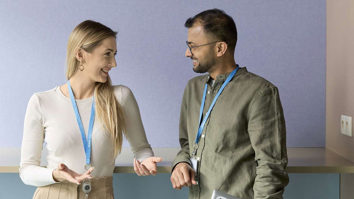 Two Orsted colleagues exchange ideas in a modern office setting.