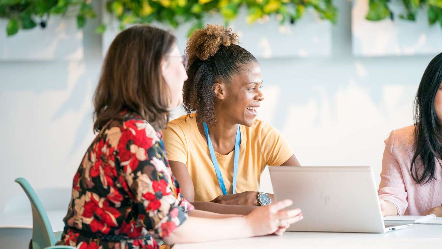Two female Ørsted employees sitting around a table with a laptop