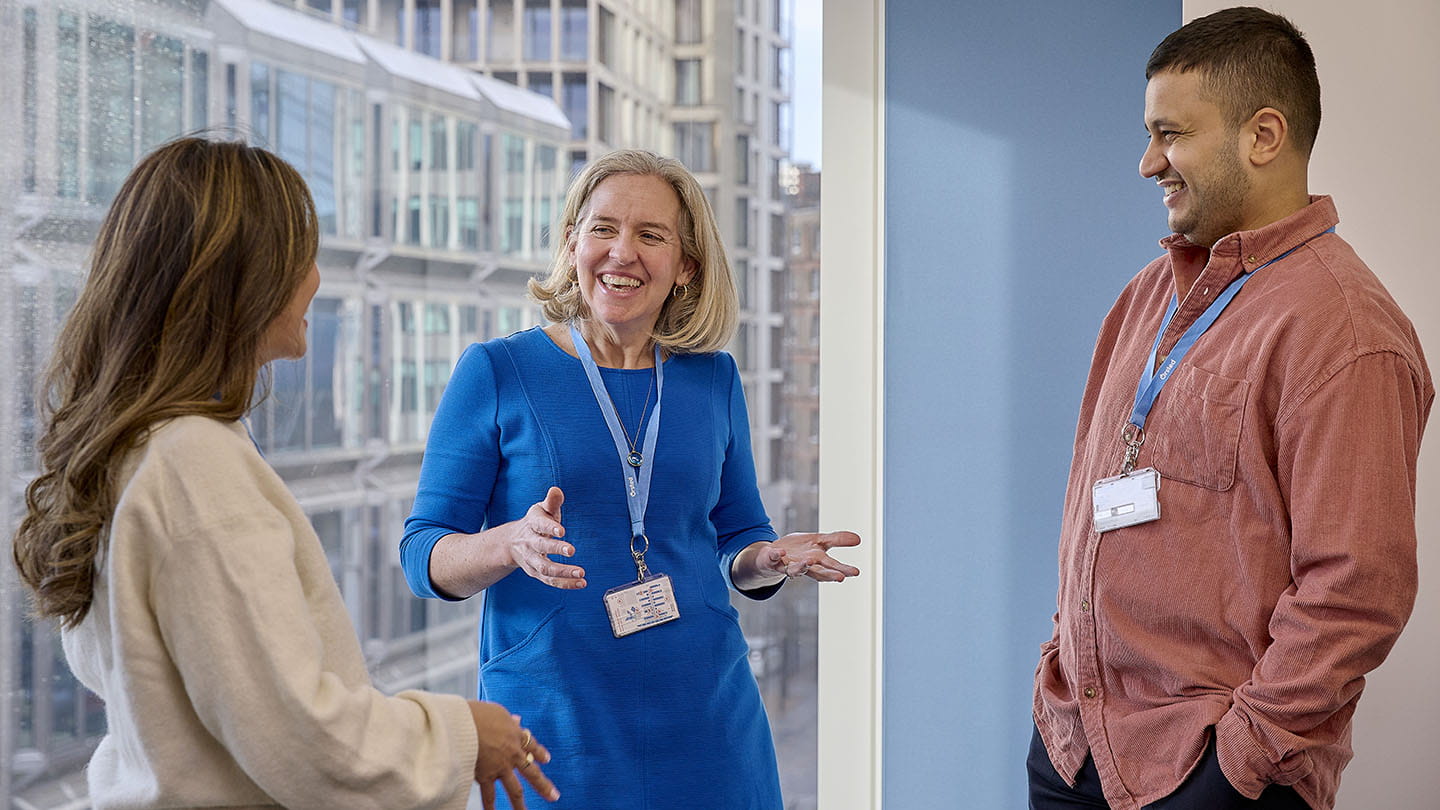 Portraits of employees standing by the window view, chatting, talking,  smiling