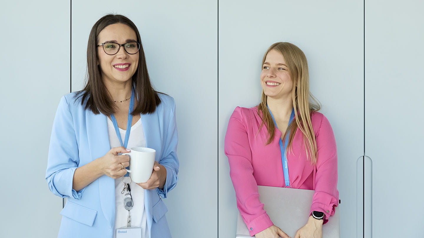 Portraits of employees standing by the wall, chatting, smiling