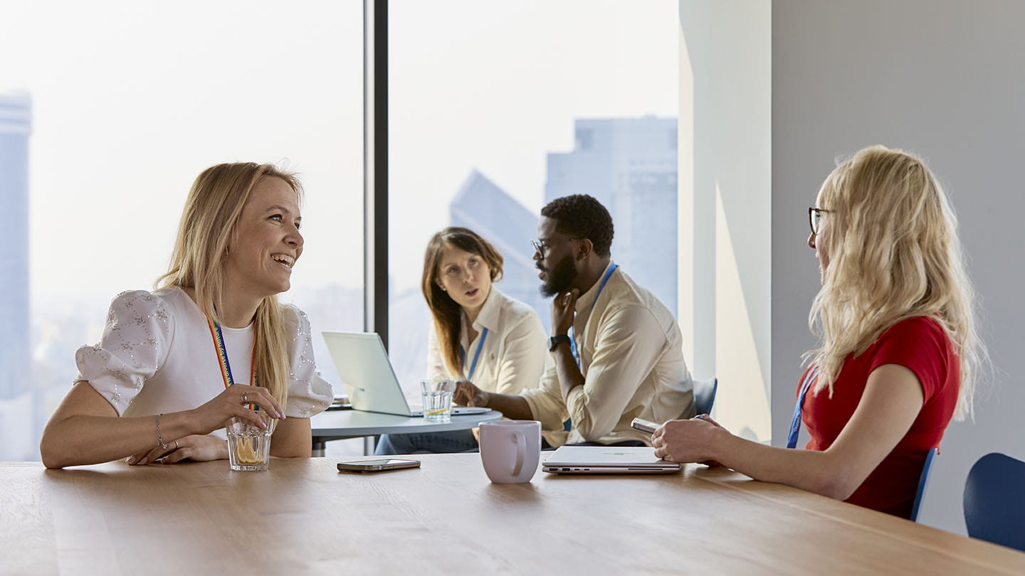 Portraits of employees sitting by a tables in the meeting room, chatting, smiling