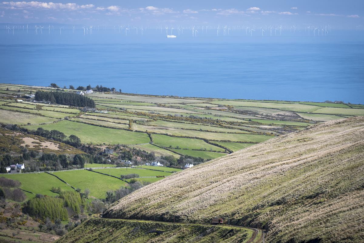 Image of the Isle of Man countryside looking down to the sea with offshore turbines in the background