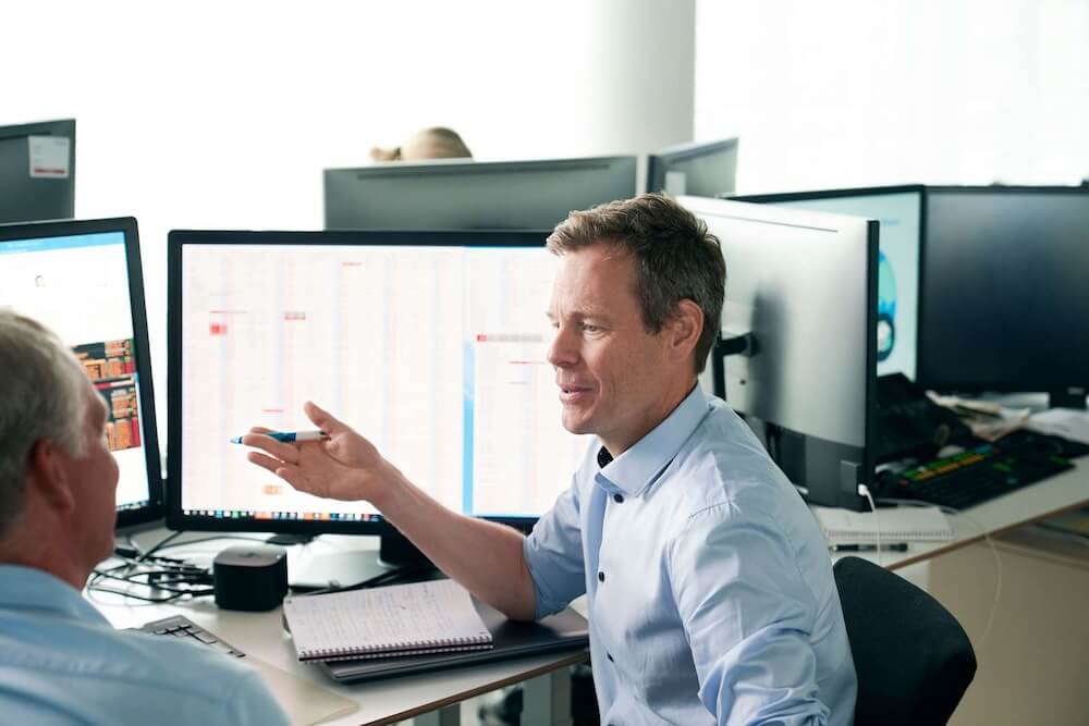 Image of an office worker sitting in front of a computer screen