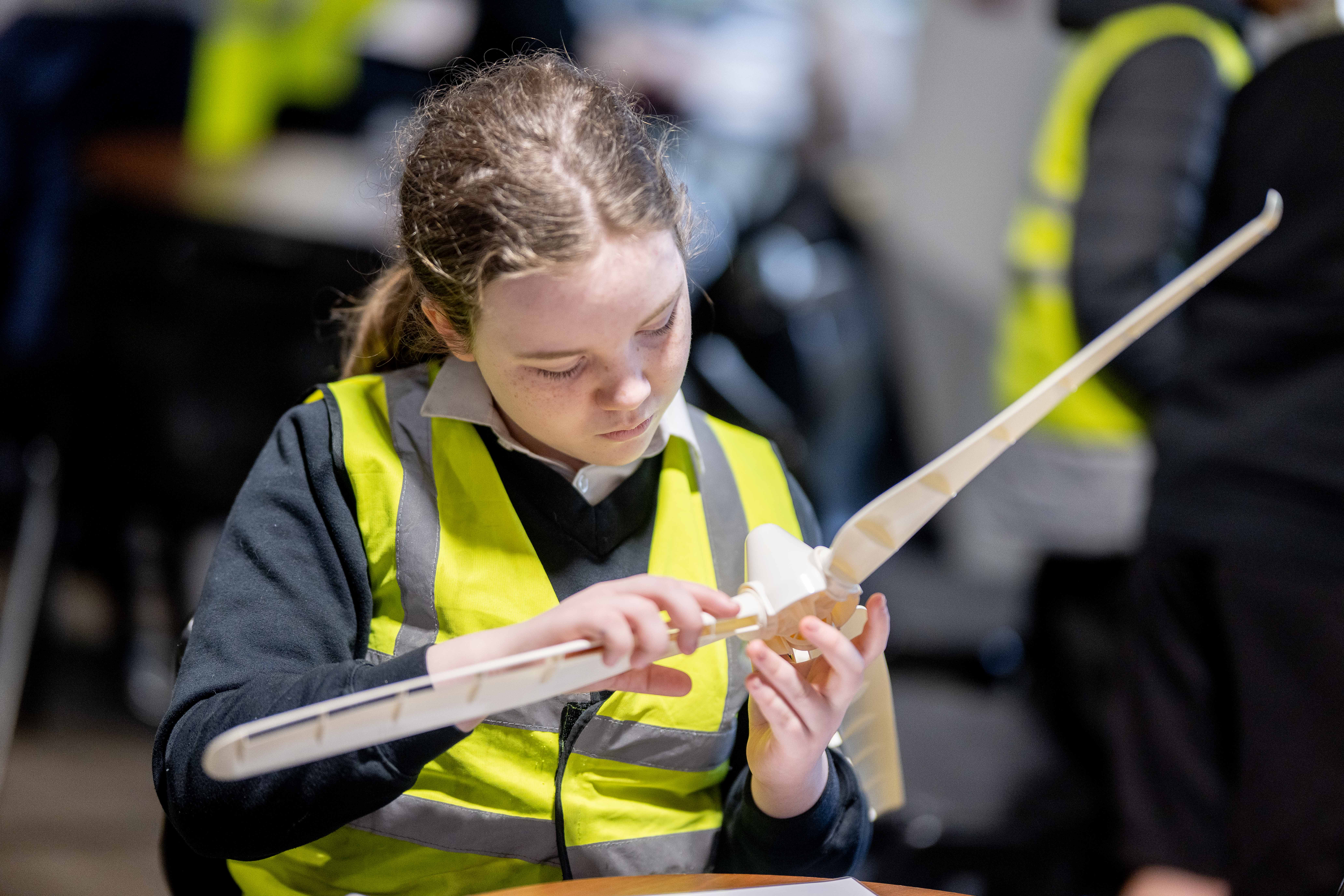 A Year 6 student examines a replica wind turbine Credit: Matt Usher