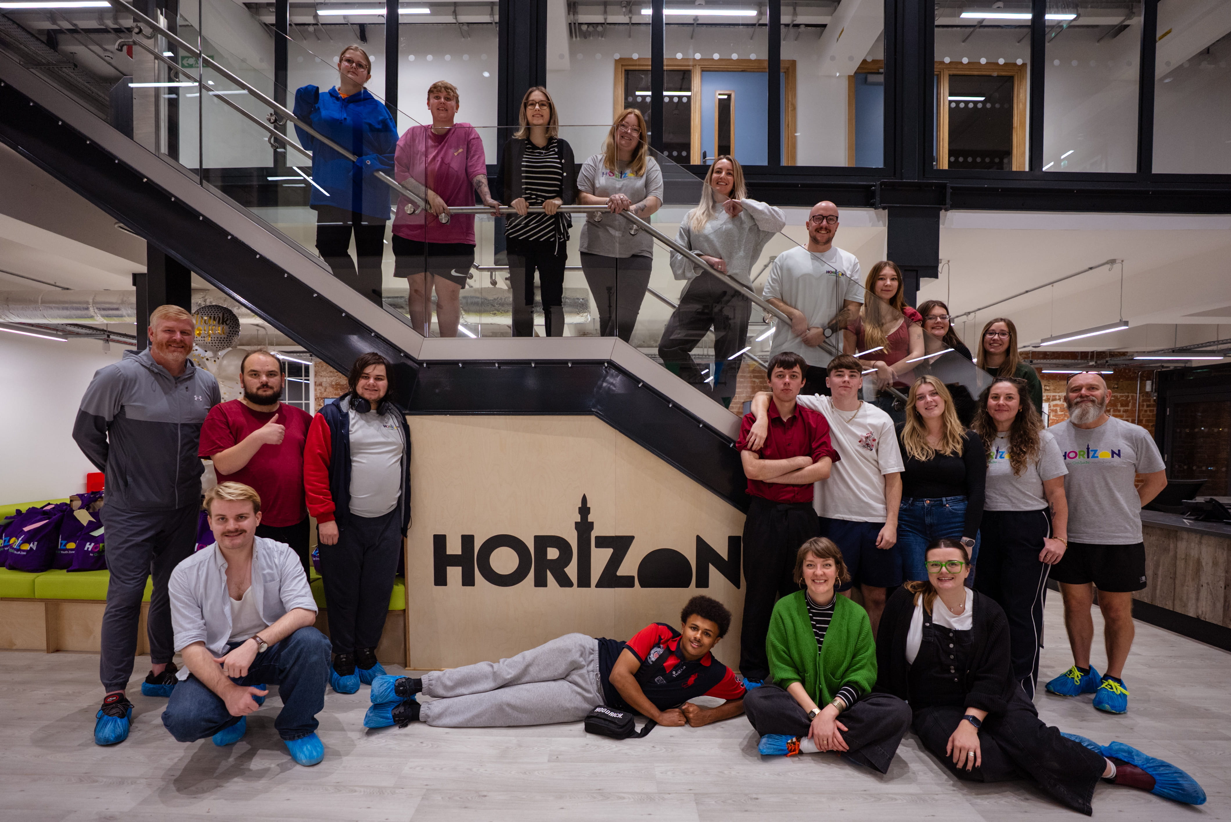 Interior shot of the Horizon Youth Zone, with people standing on and around a central staircase