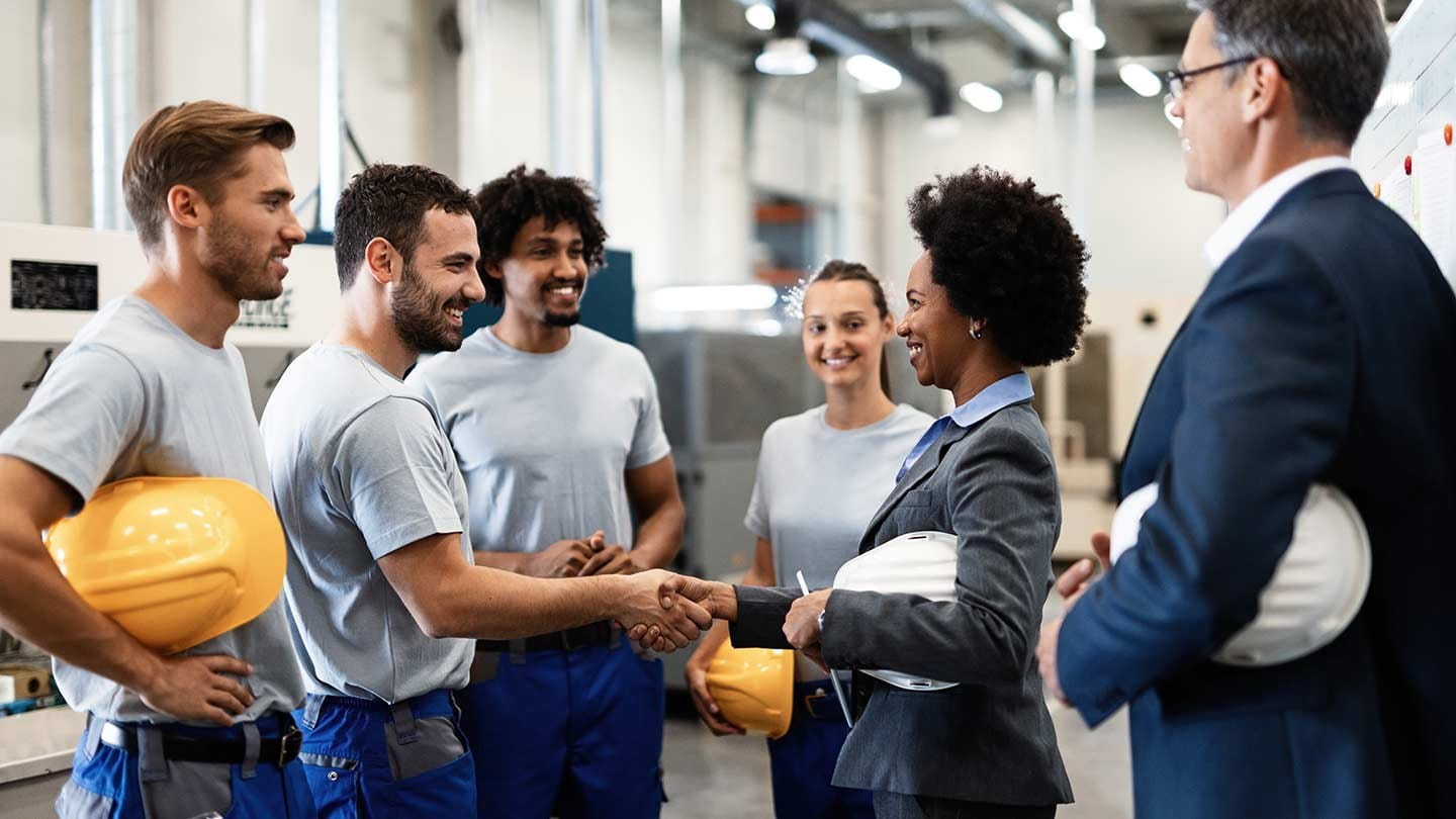 A man and a woman shaking hands and smiling.