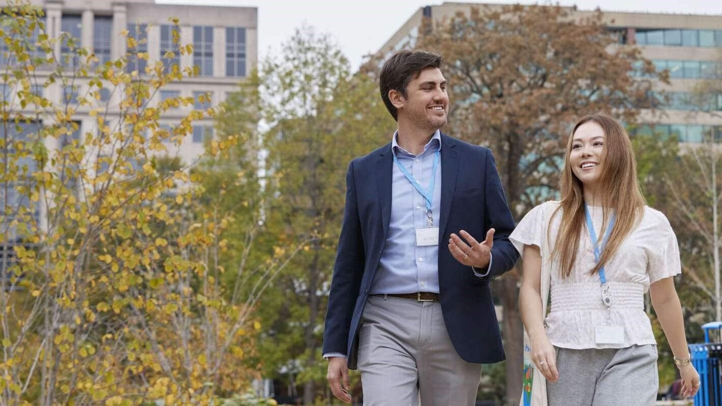 One male and one female Ørsted employee walking in downtown Washington D.C., working for a leading clean energy company.